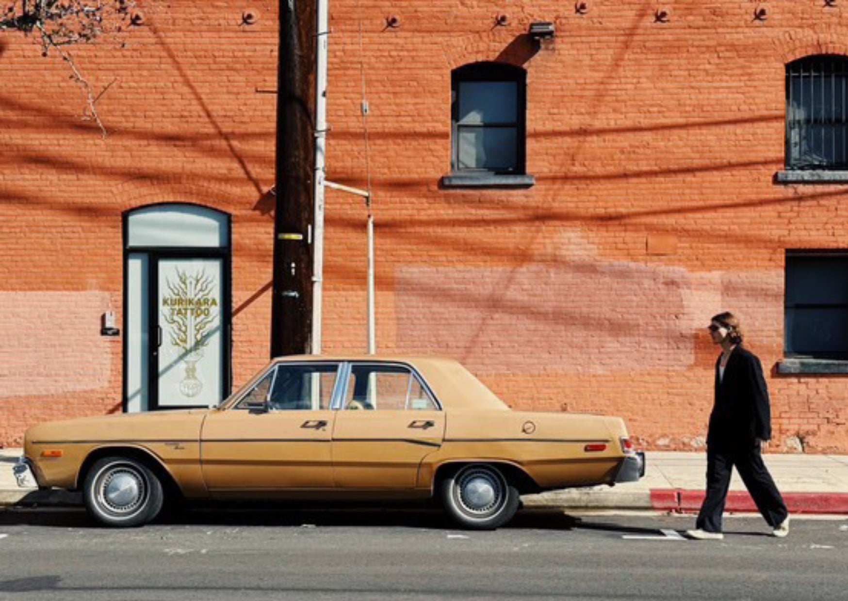 Will walking past a vintage car and red brick building in the Los Angeles Arts District｜Will 走過 Los Angeles Arts District 的紅磚建築與復古汽車