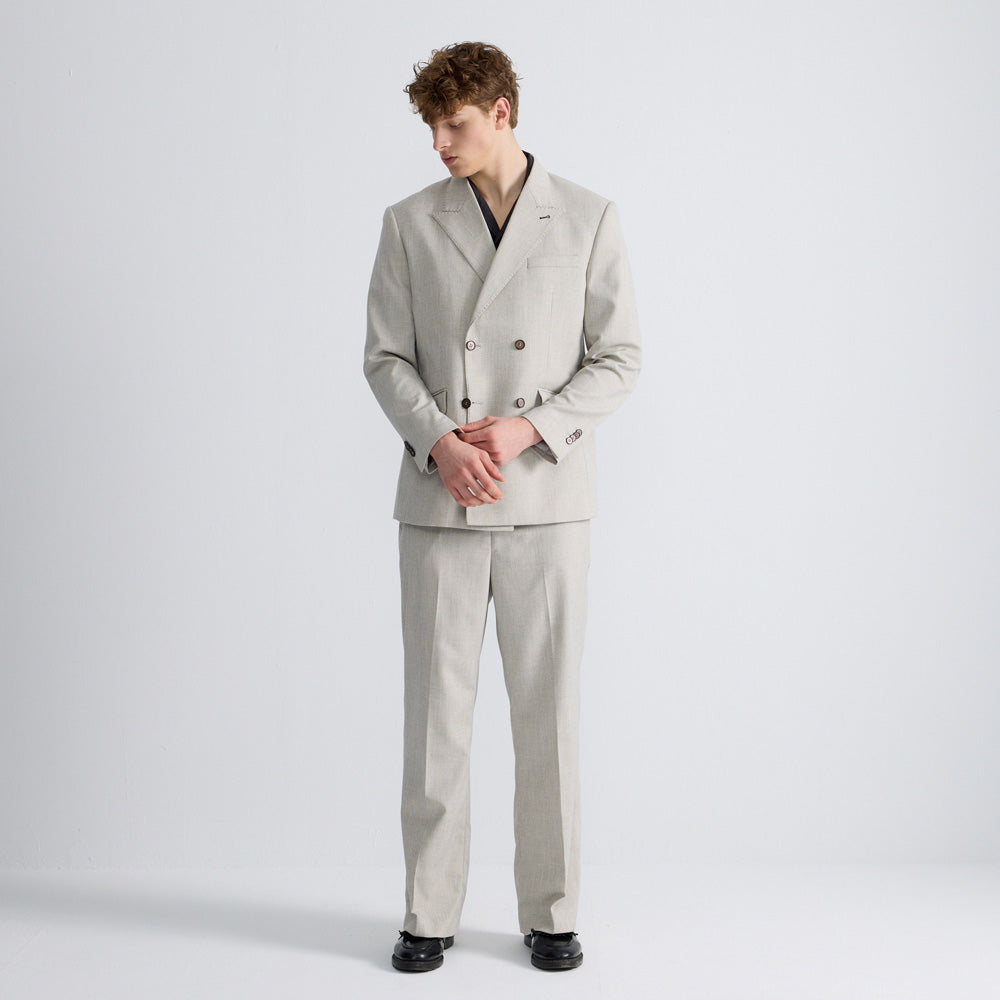 Male model wearing an ARVOpm light grey mélange relaxed double-breasted suit with straight-leg trousers